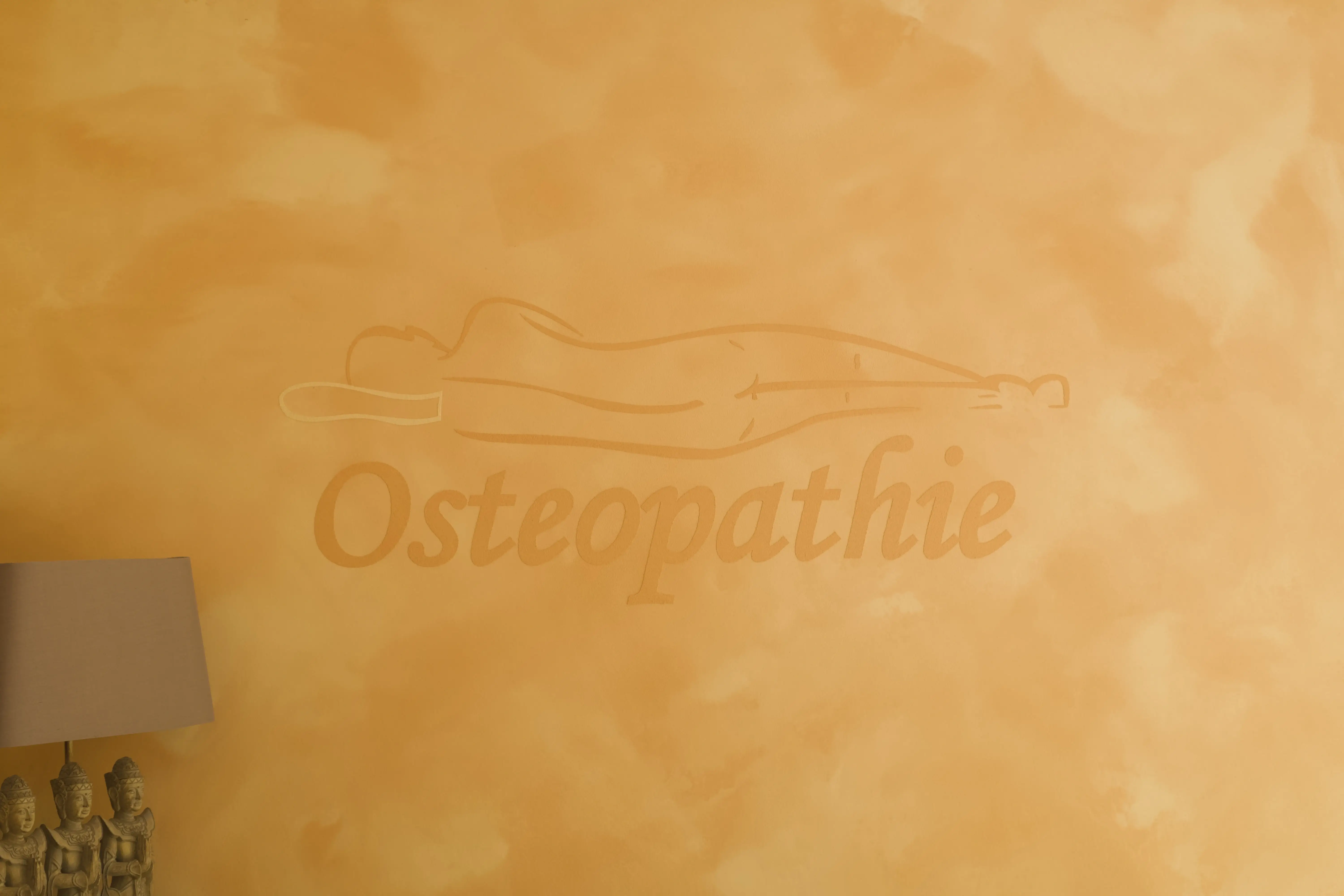 Dekorativer Schriftzug Osteopathie an der Innenwand der Praxis von Jeannette Aporius in Fredersdorf
