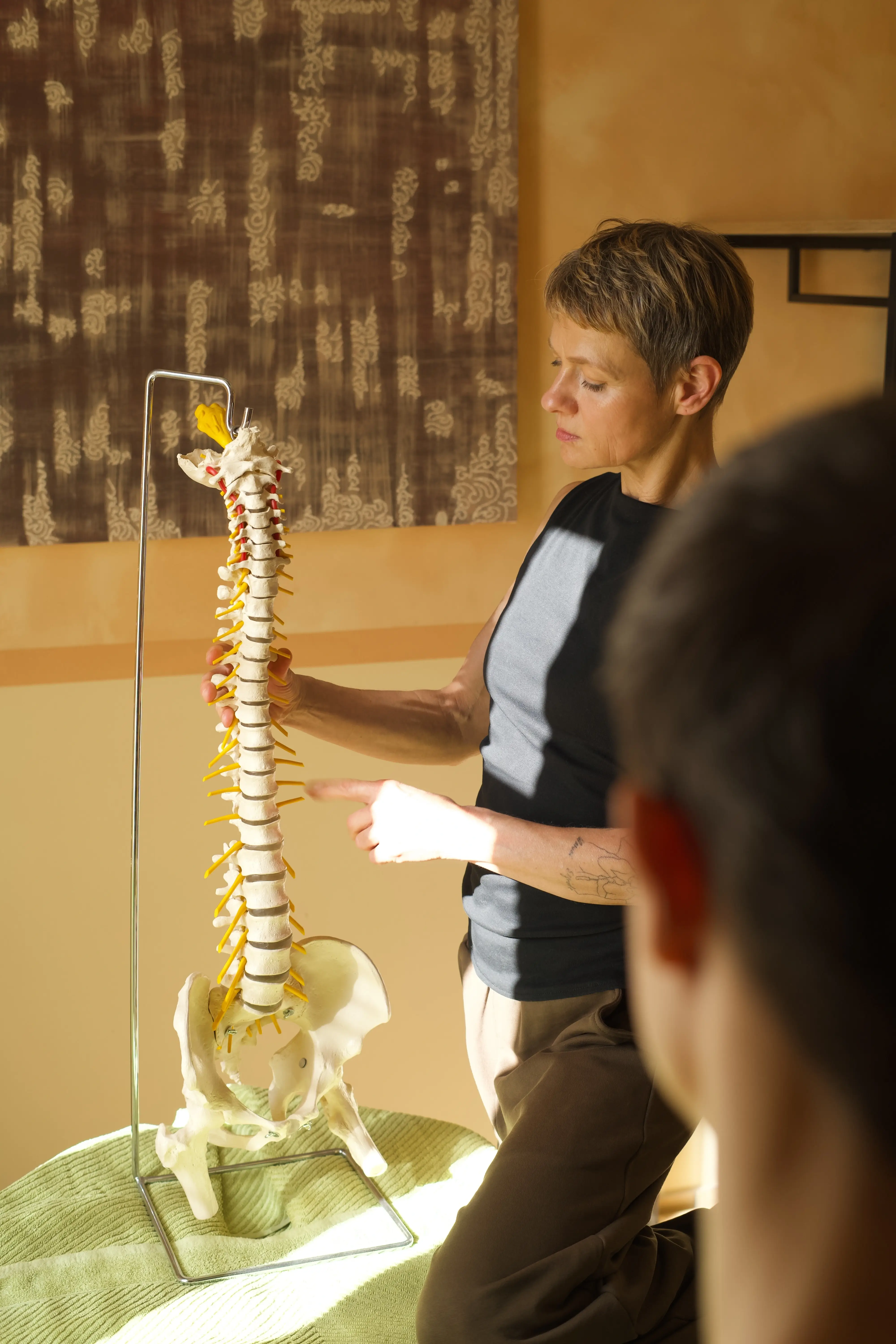 Jeannette Aporius erklärt einem Patienten einen Bandscheibenvorfall an einem lebensgroßen Wirbelsäulenmodell